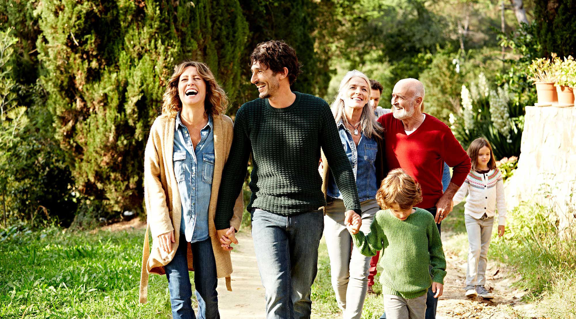 Multi-genrational family walking in the park.